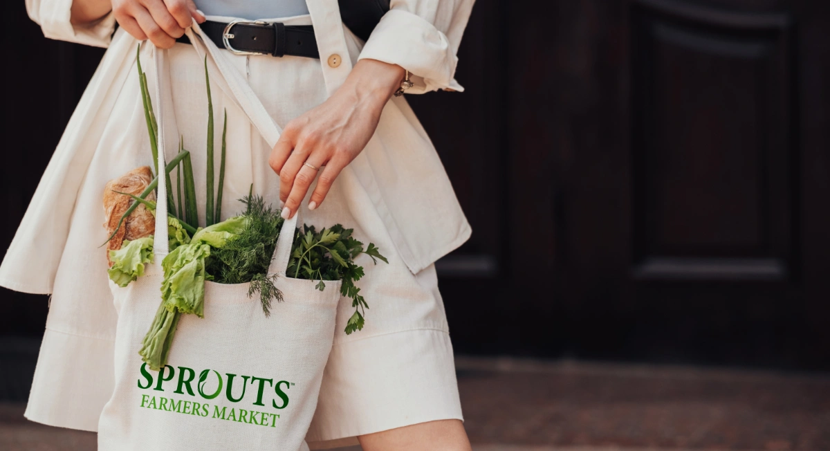 Person carrying fresh groceries while walking up outdoor steps.
